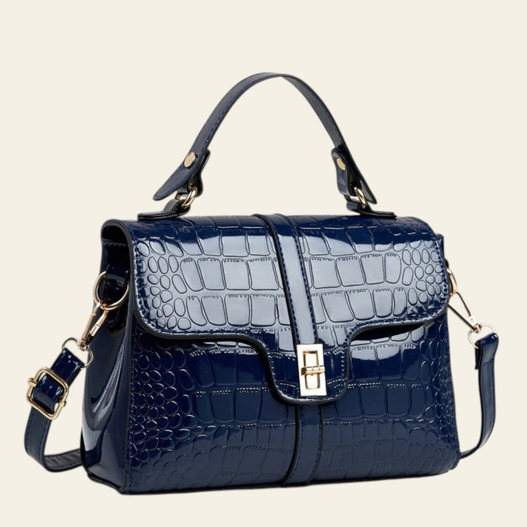 Blue crocodile-patterned handbag on a light gray background