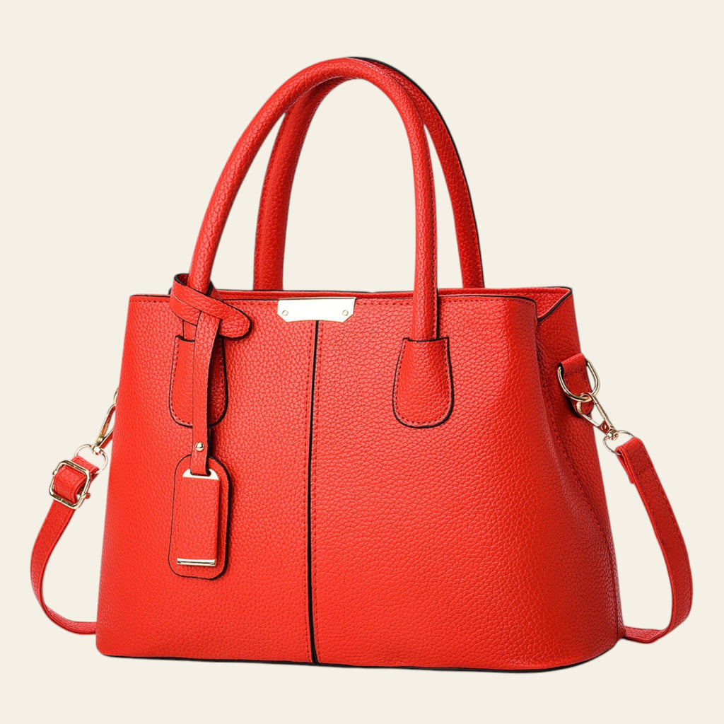 Red handbag with gold accents on a light gray background