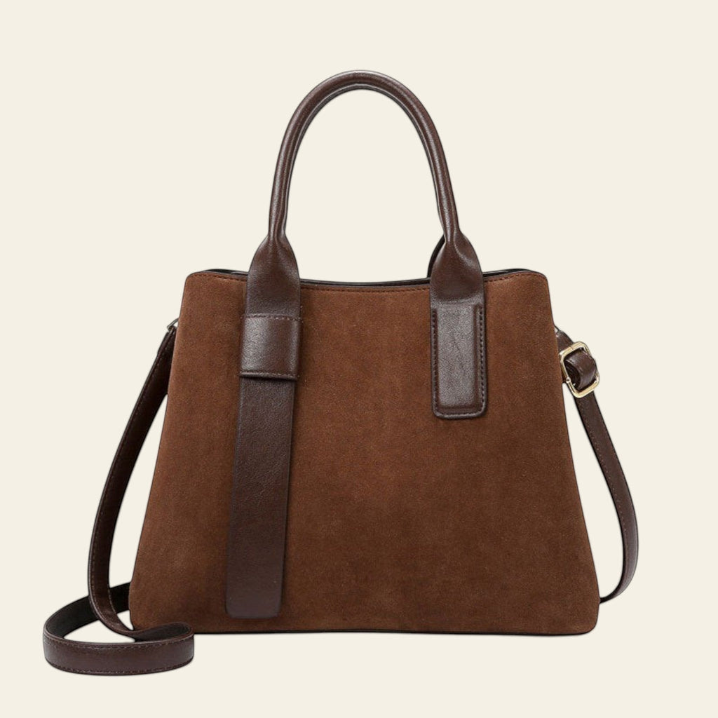 Brown handbag with a matching strap and an orange box in the background