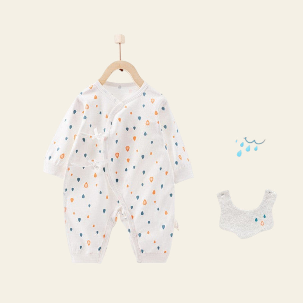 Baby onesie with colorful patterns on a hanger, accompanied by a bib on a white background.