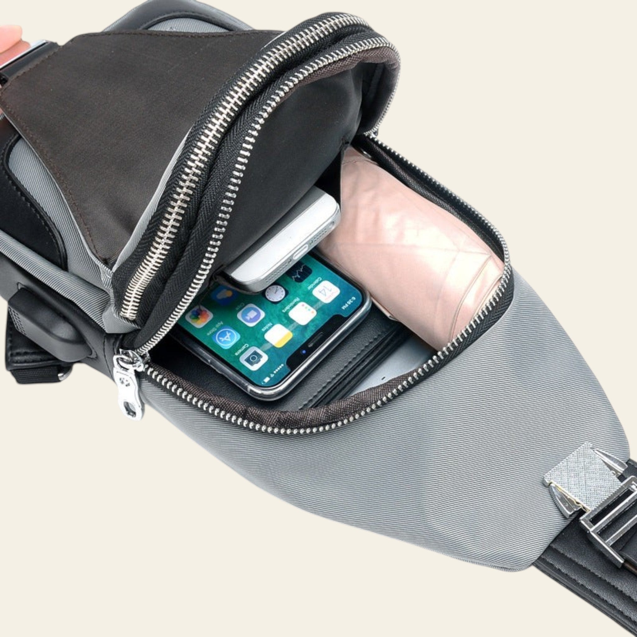 Gray waist bag with a phone and other items on a white background