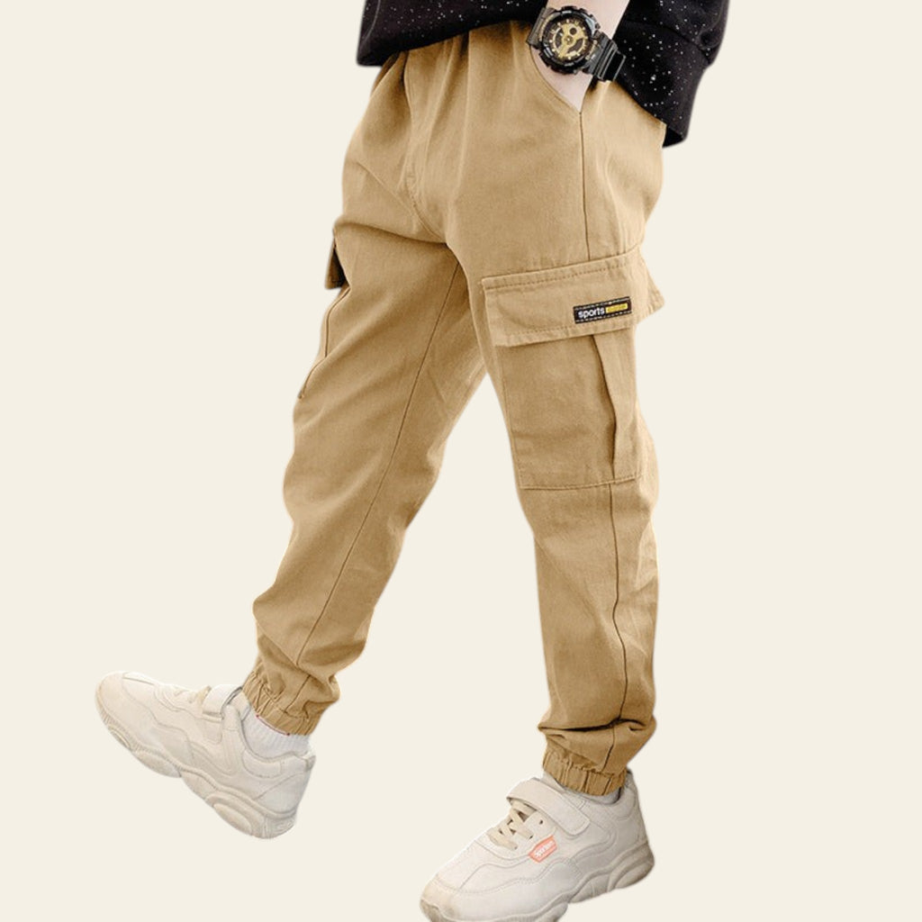 Person wearing beige cargo pants and white sneakers in an indoor setting.