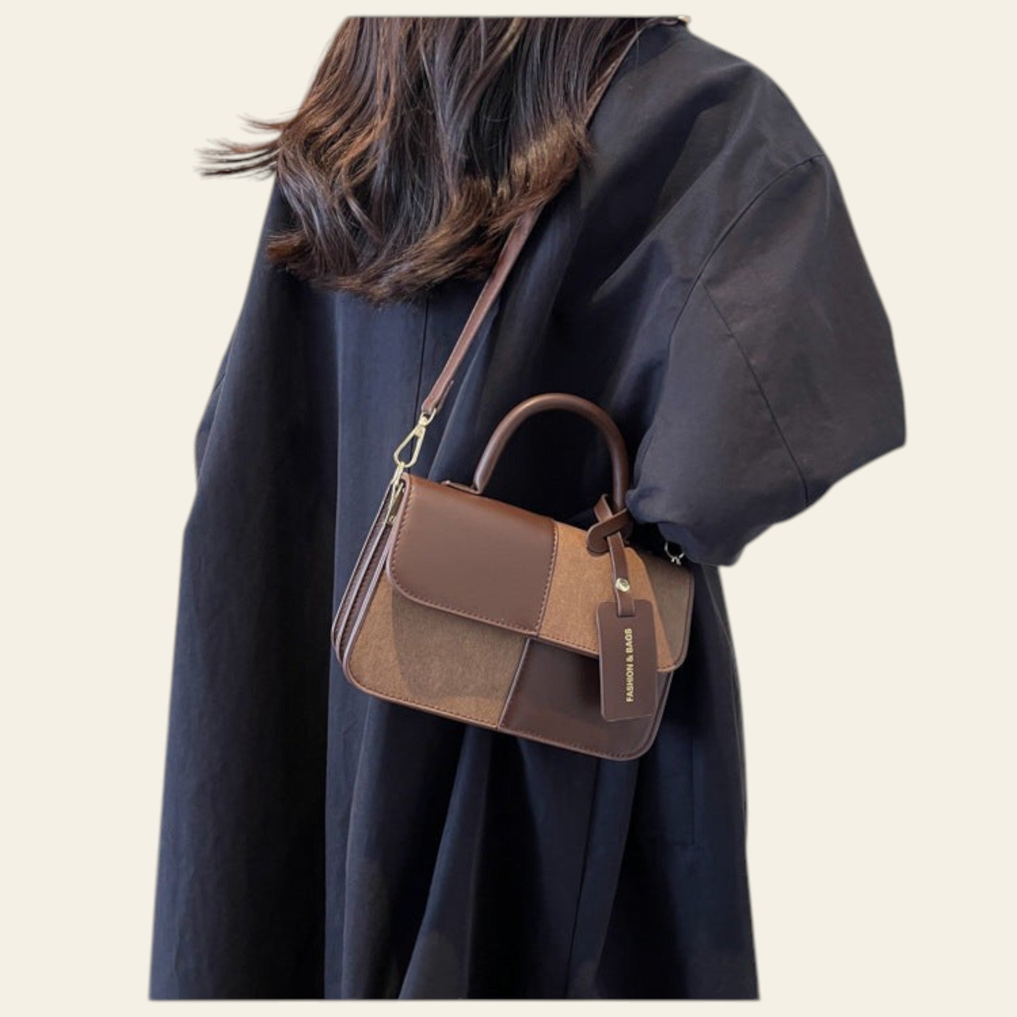 Person wearing a brown and black handbag against a neutral background