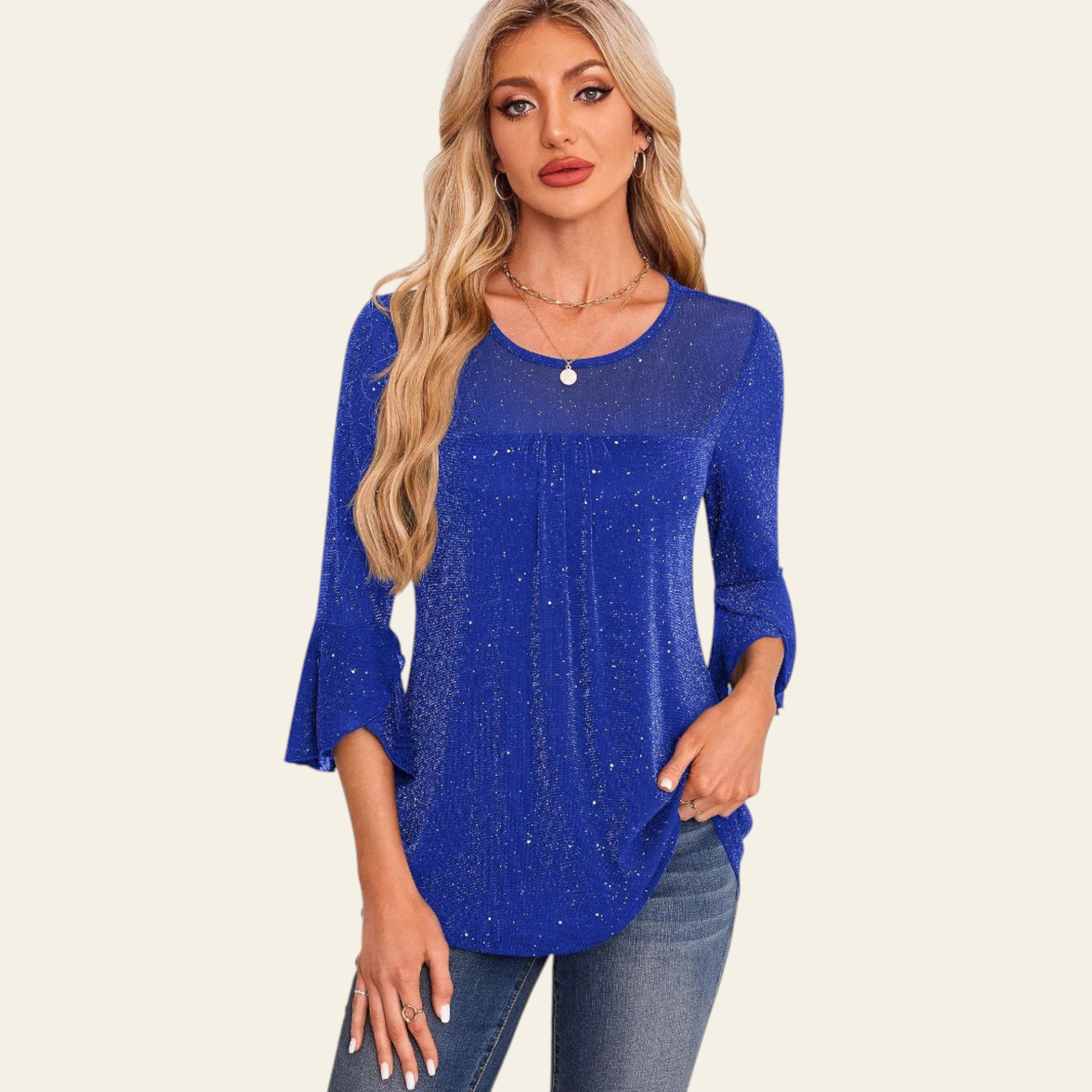 Woman wearing a blue top with a white wall and decorative elements in the background
