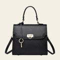 Black handbag with gold accents on a white background