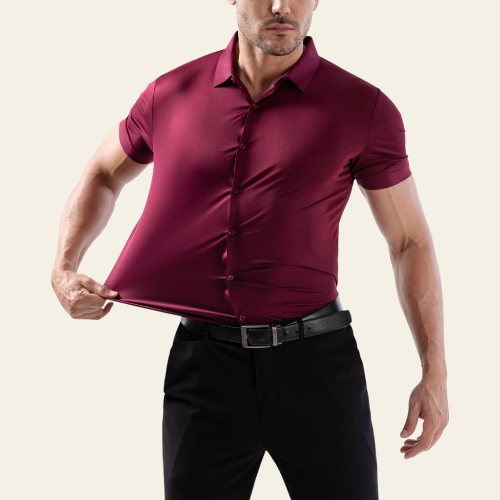 Man wearing a maroon shirt and black pants on a white background