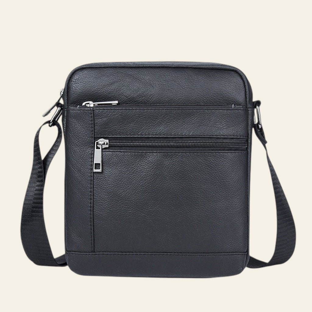 Black leather crossbody bag with zippers on a white background
