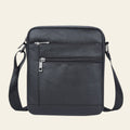 Black leather crossbody bag with zippers on a white background