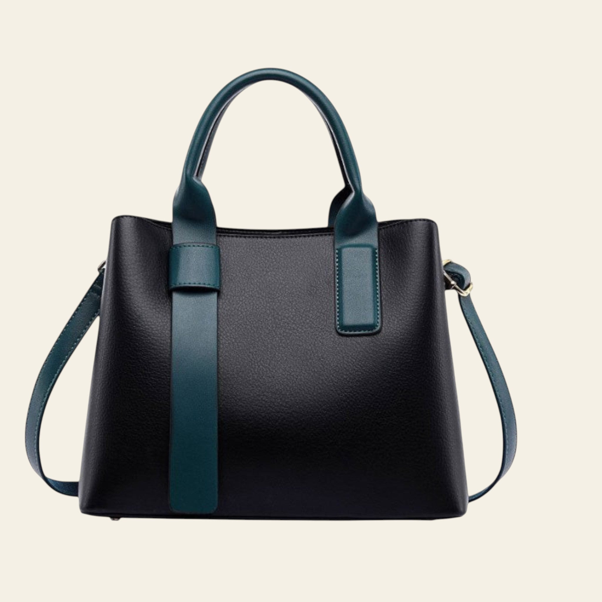 Black handbag with green handles and strap, accompanied by an orange gift box on a white background.