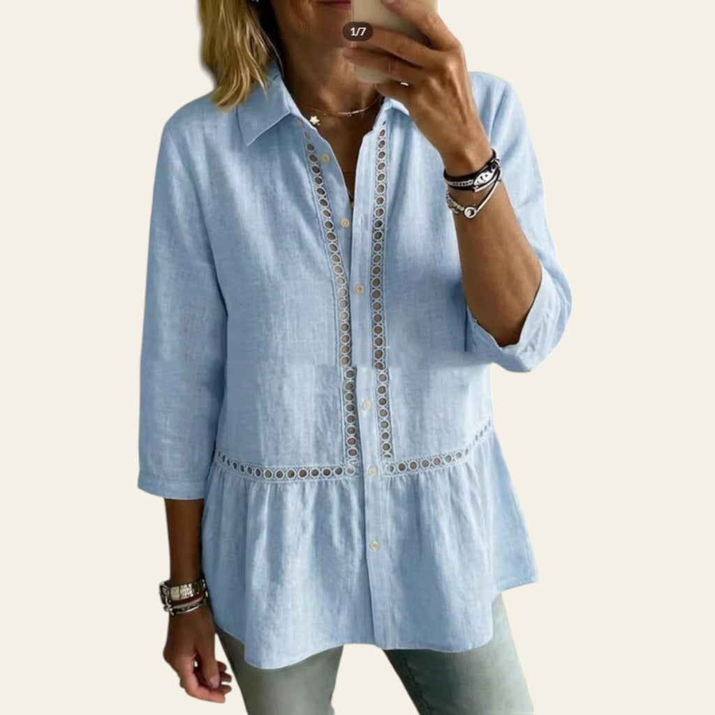 Person wearing a light blue shirt with intricate detailing in a home setting.