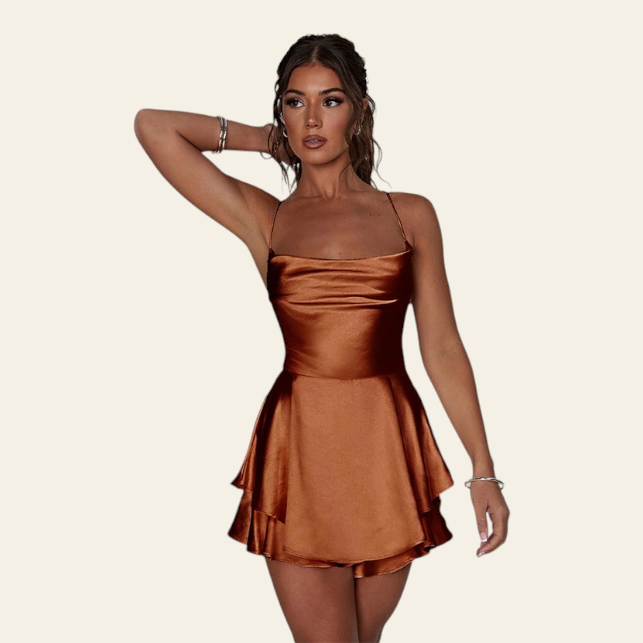 Woman wearing a bronze satin dress against a plain background