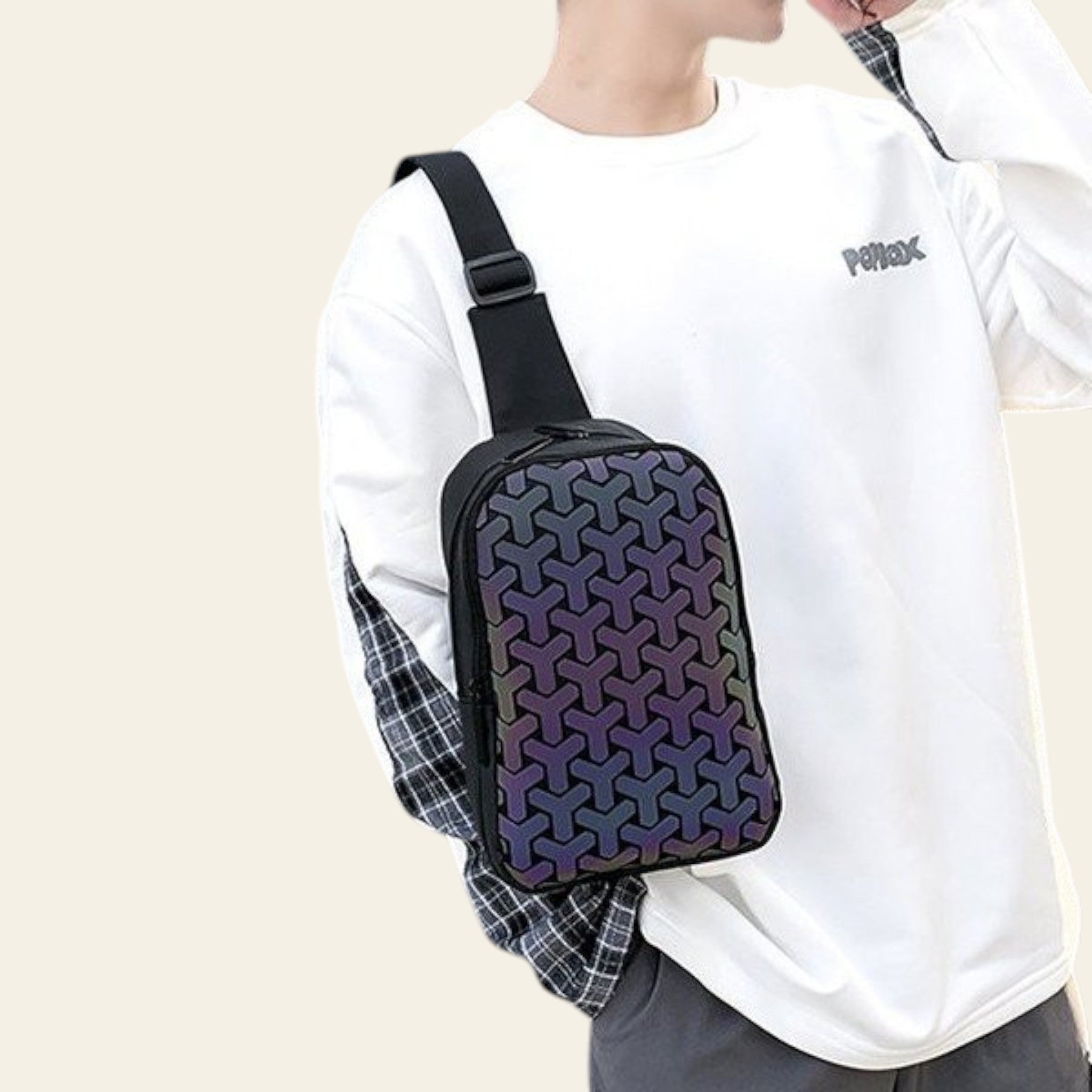 Person wearing a black patterned crossbody bag outdoors.
