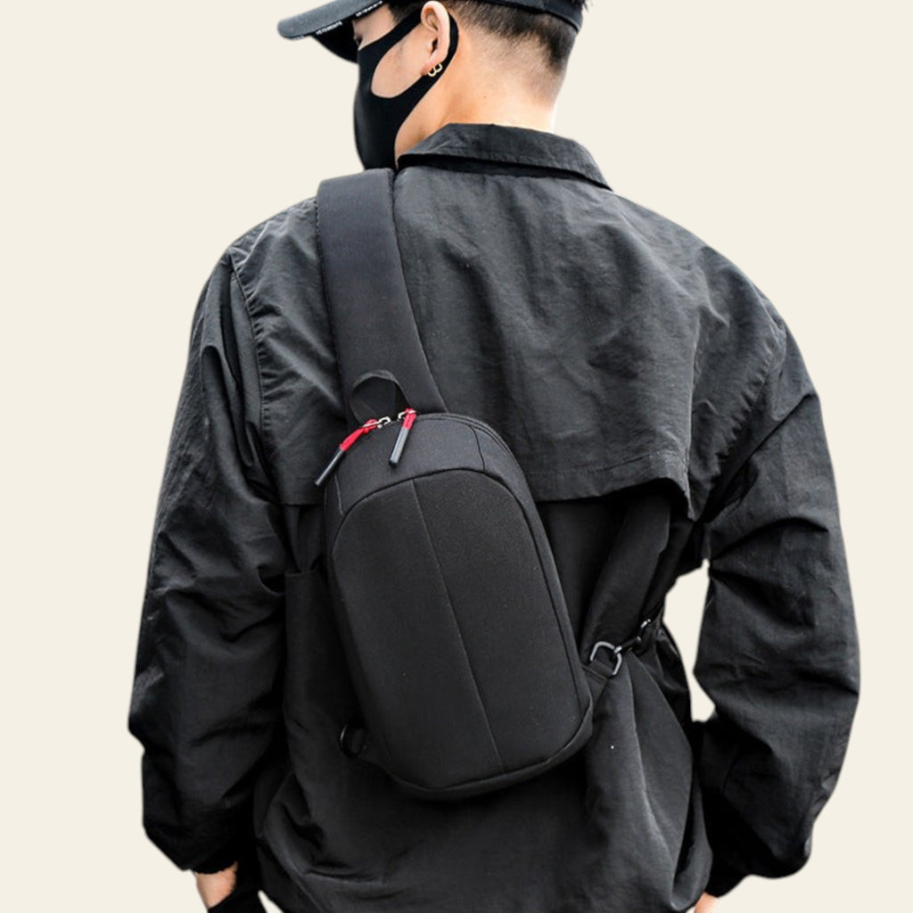 Person wearing a black backpack with a red zipper on a staircase.