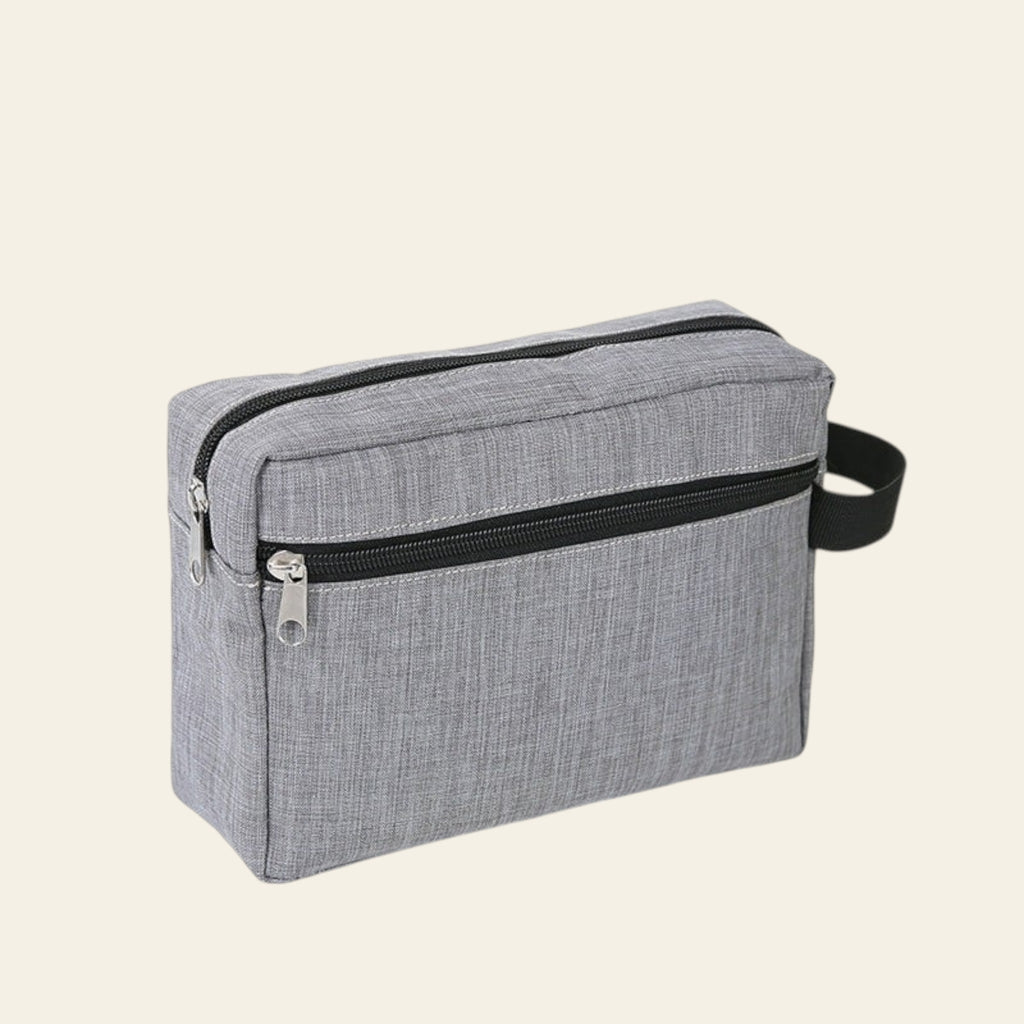 Gray toiletry bag with black zipper on a white background