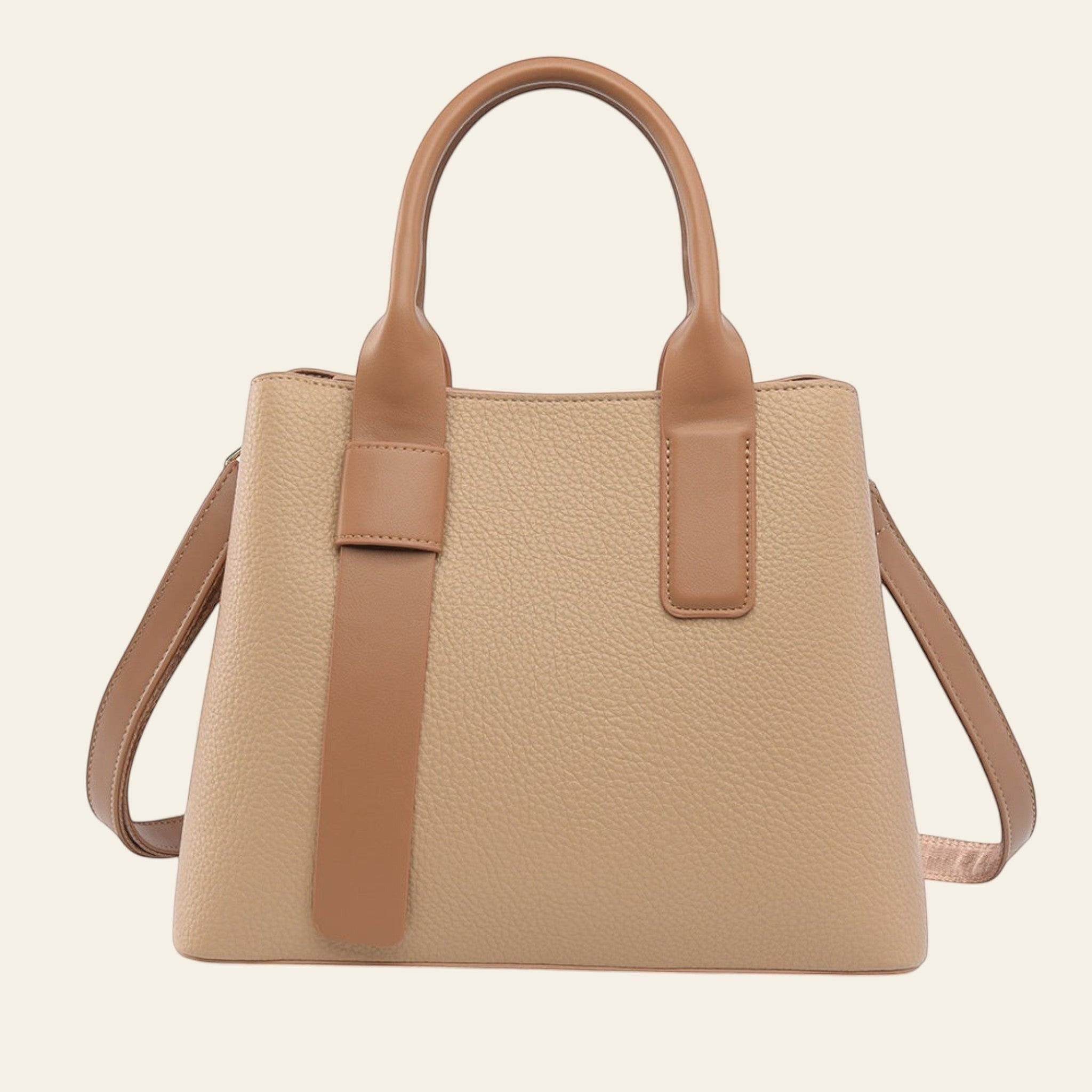 Beige handbag with brown handles and strap on a white background
