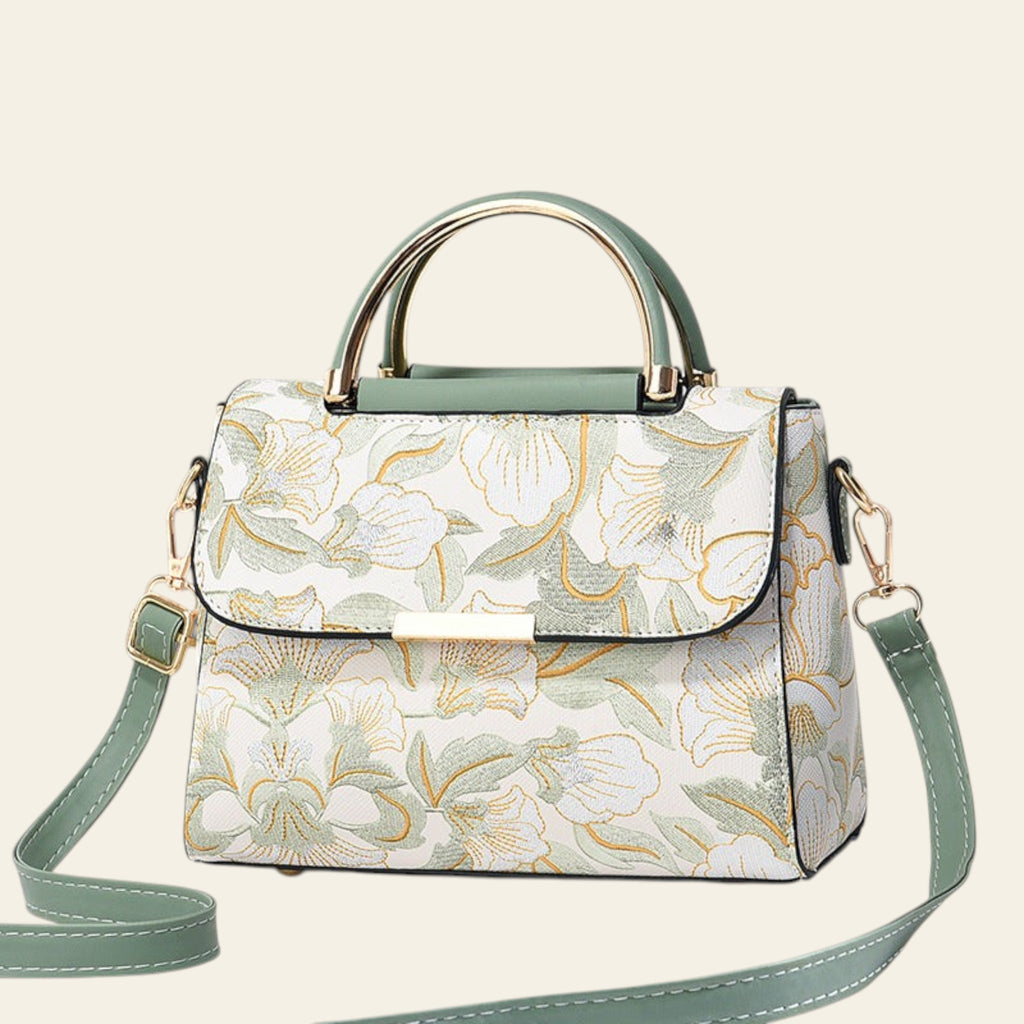 Floral patterned handbag with green accents on a light gray background