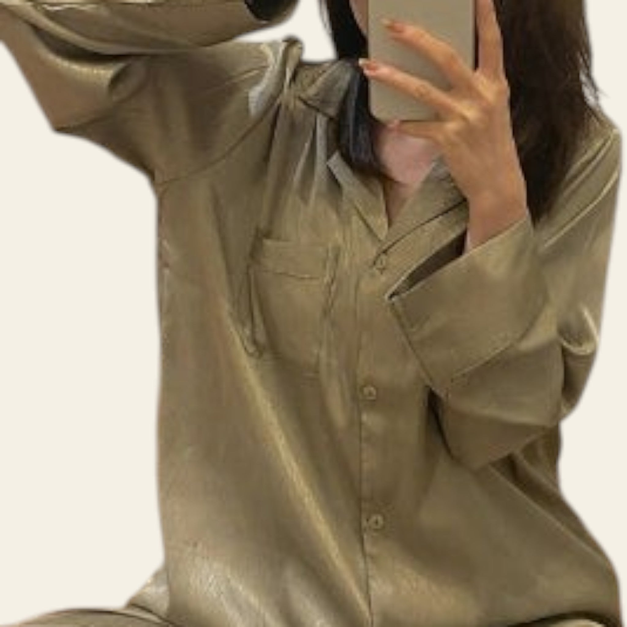 Person wearing a beige outfit taking a mirror selfie.