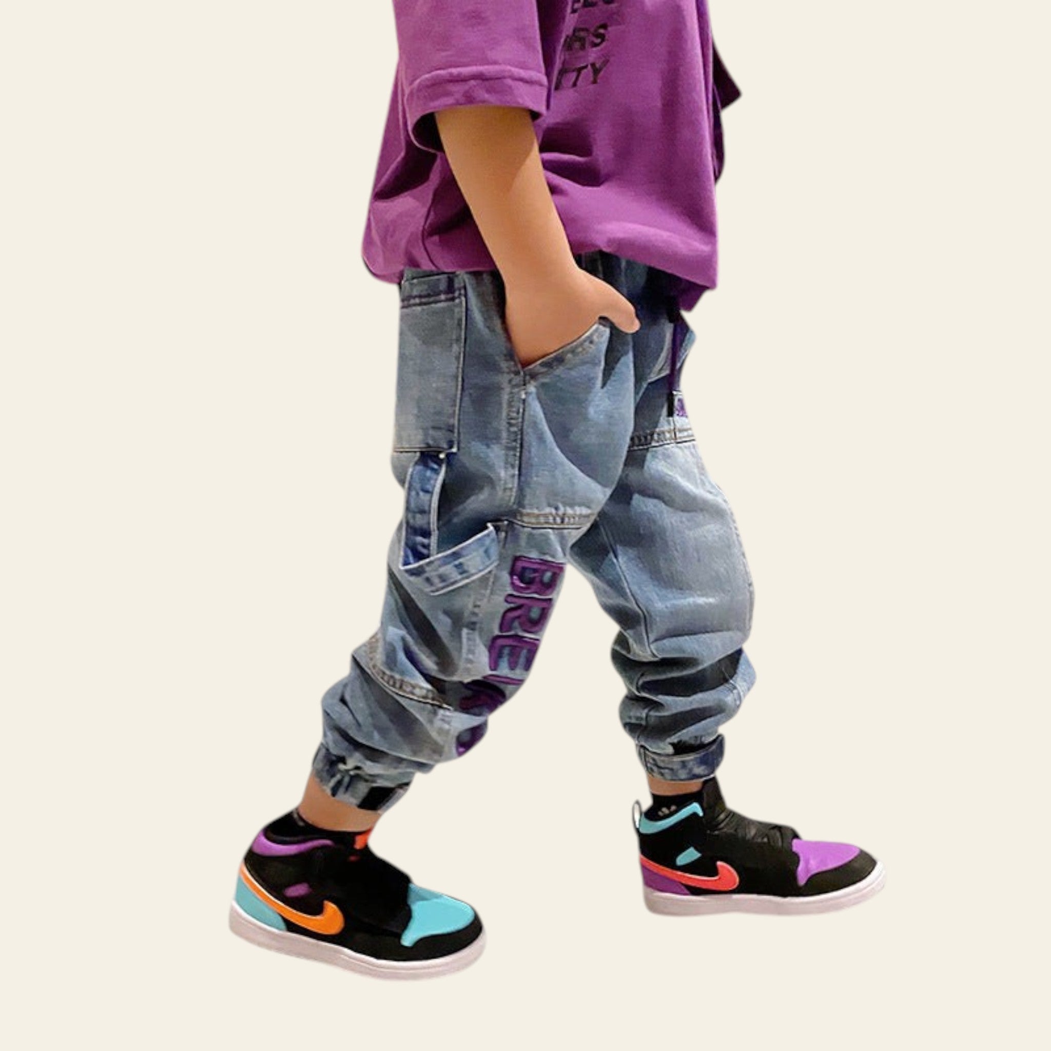 Person wearing colorful sneakers and baggy jeans in a living room setting