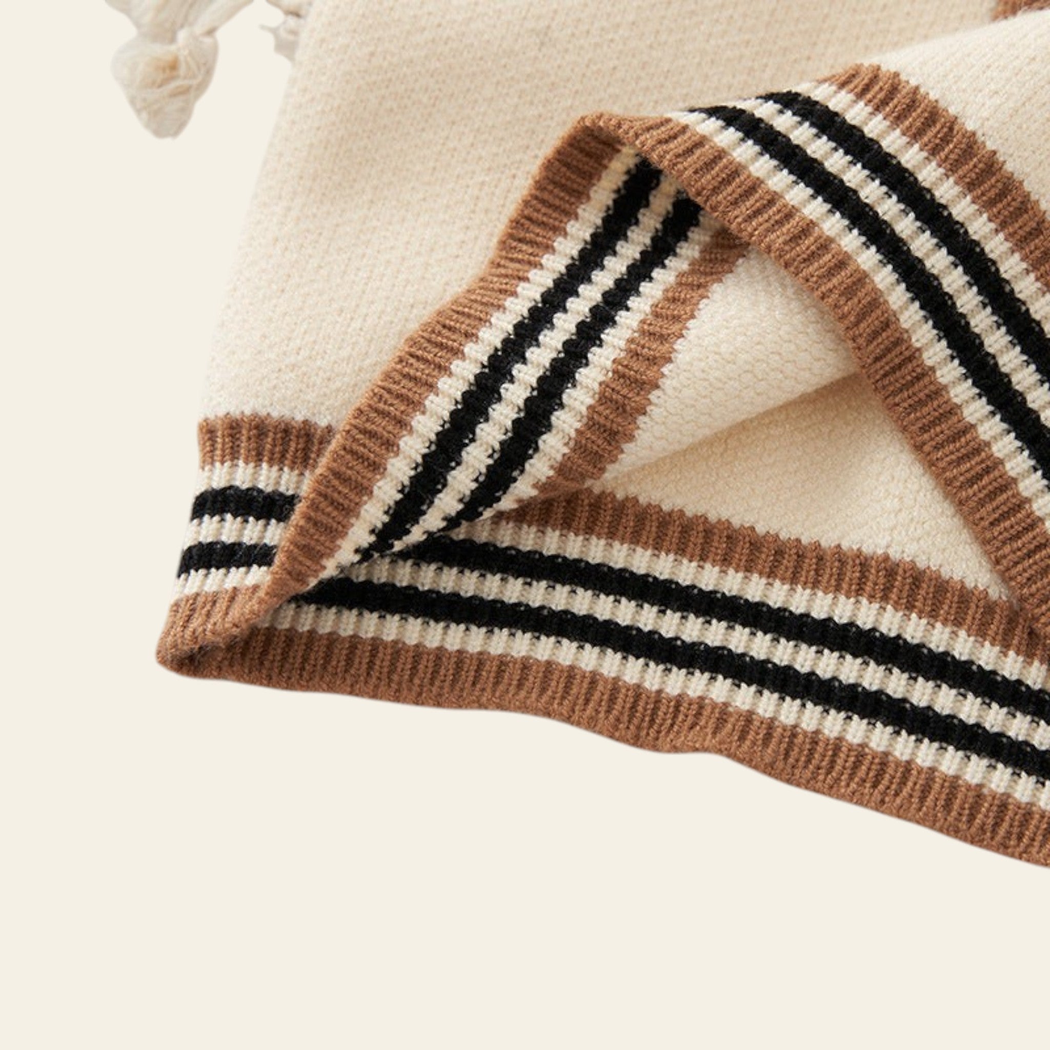 Knitted blanket with brown and black stripes on a light background