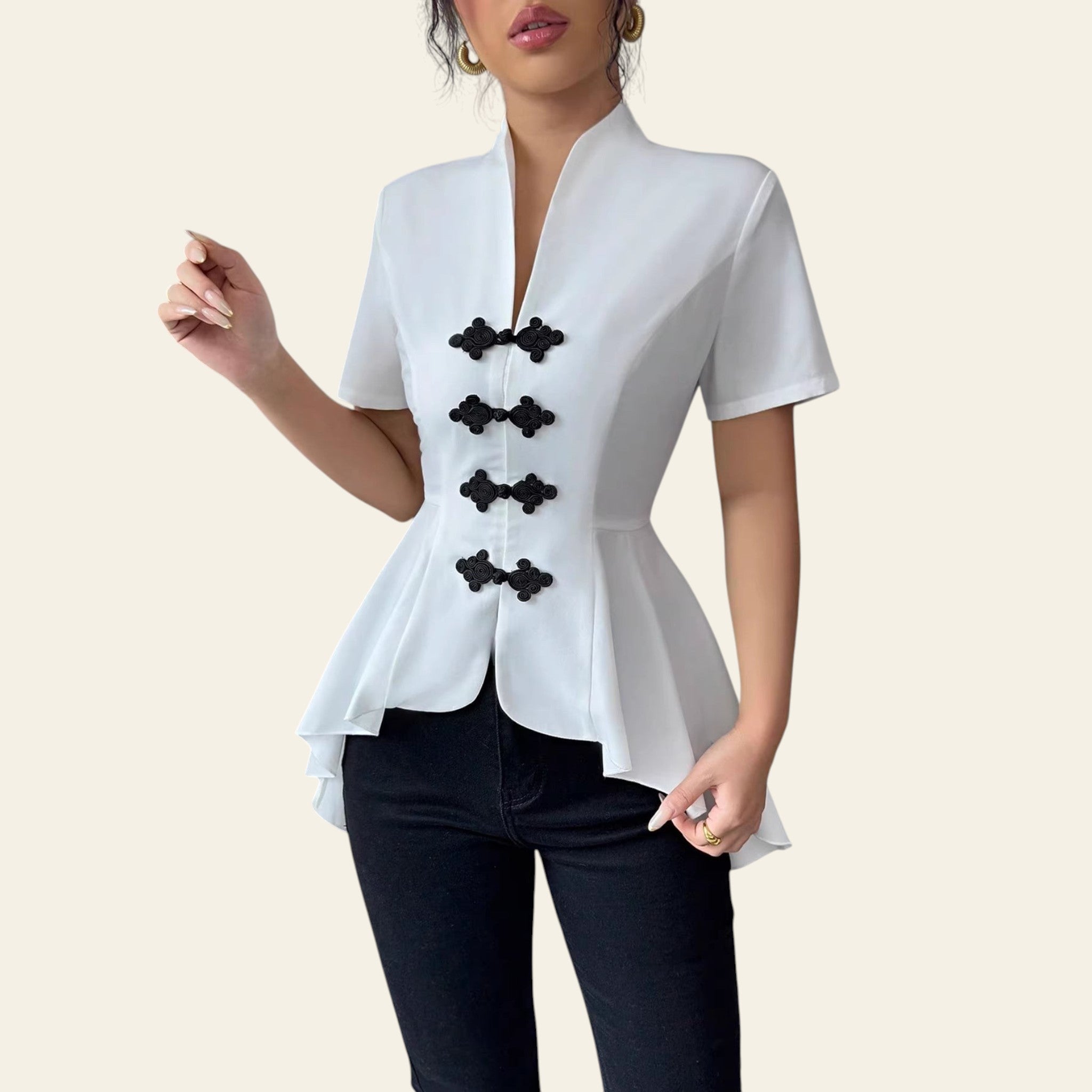 White blouse with black buttons worn by a person against a neutral background