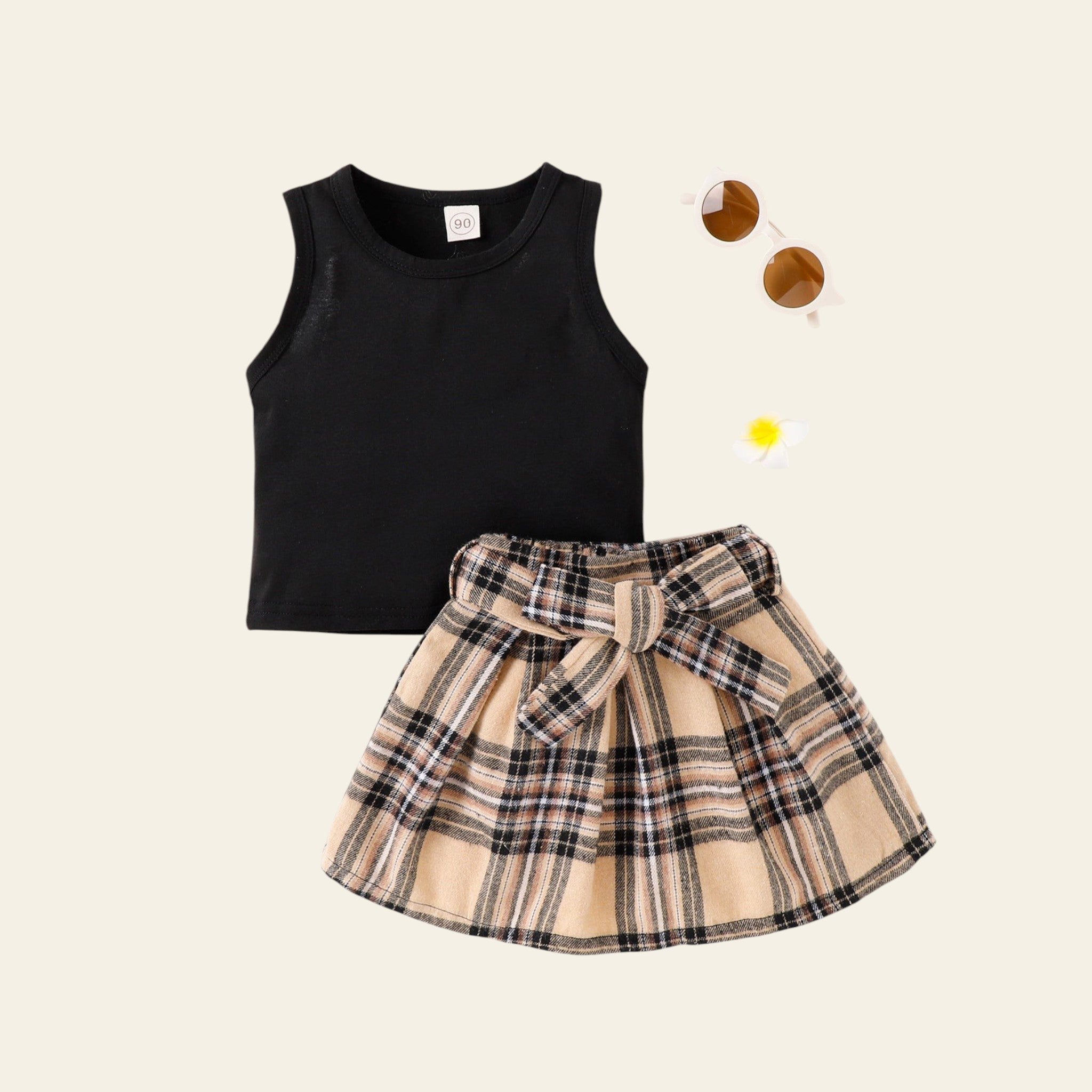 Black tank top and plaid skirt set on a white background