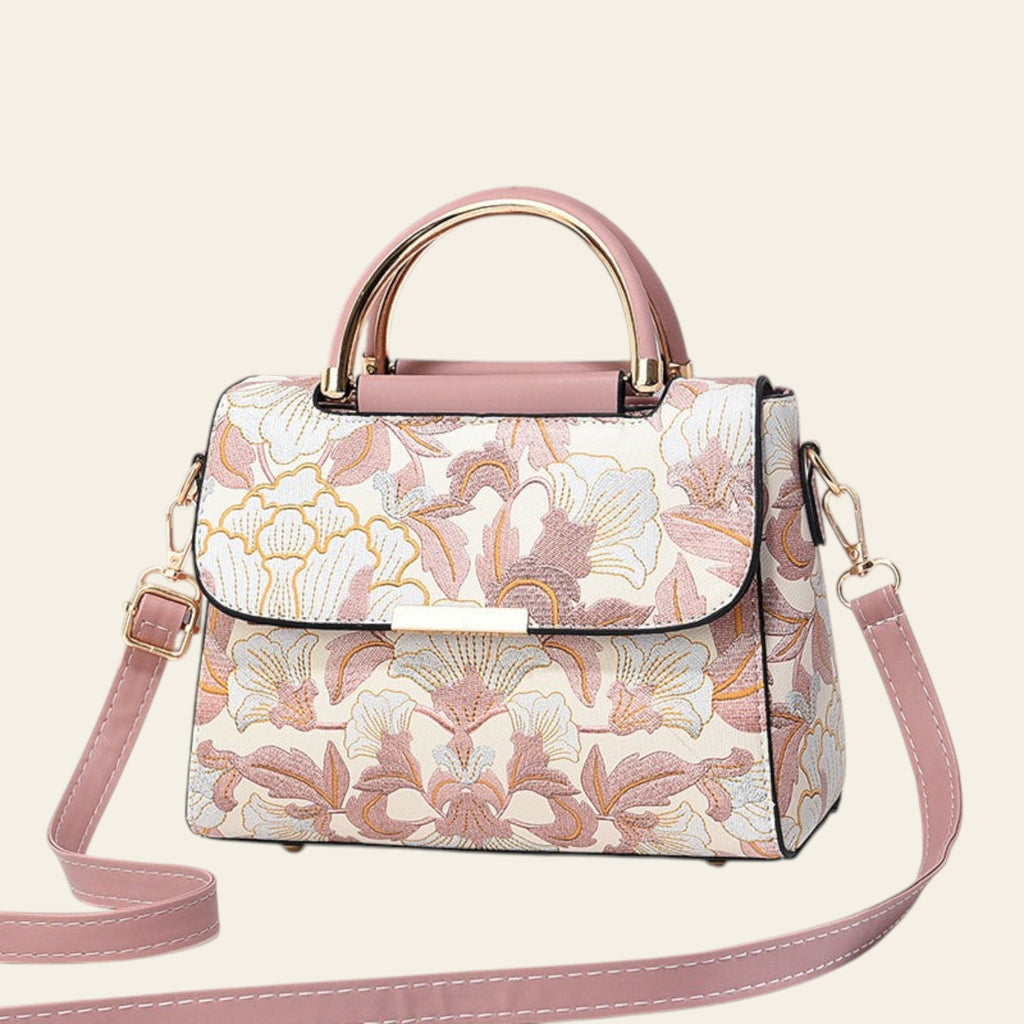 Floral patterned handbag with pink accents on a light gray background