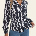 Person wearing a black and white patterned shirt with blue jeans on a neutral background