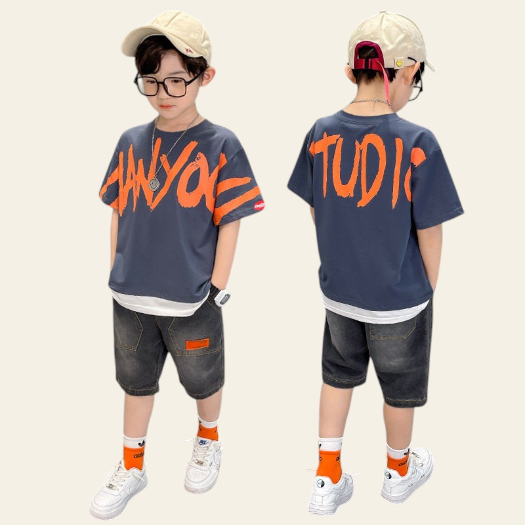 Two children wearing navy blue t-shirts with orange text, standing in front of a gray wall.