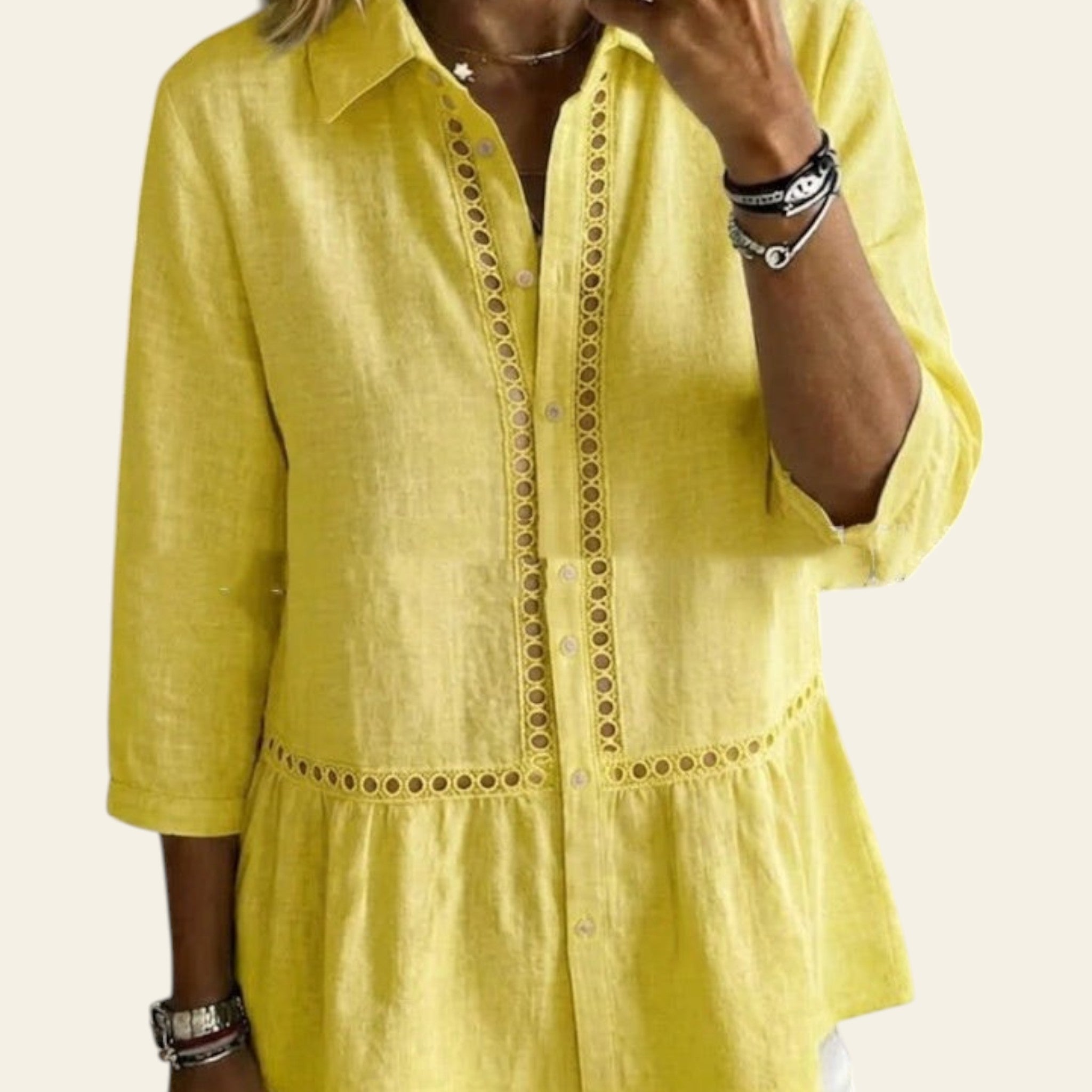 Person wearing a yellow shirt with intricate detailing in an indoor setting.