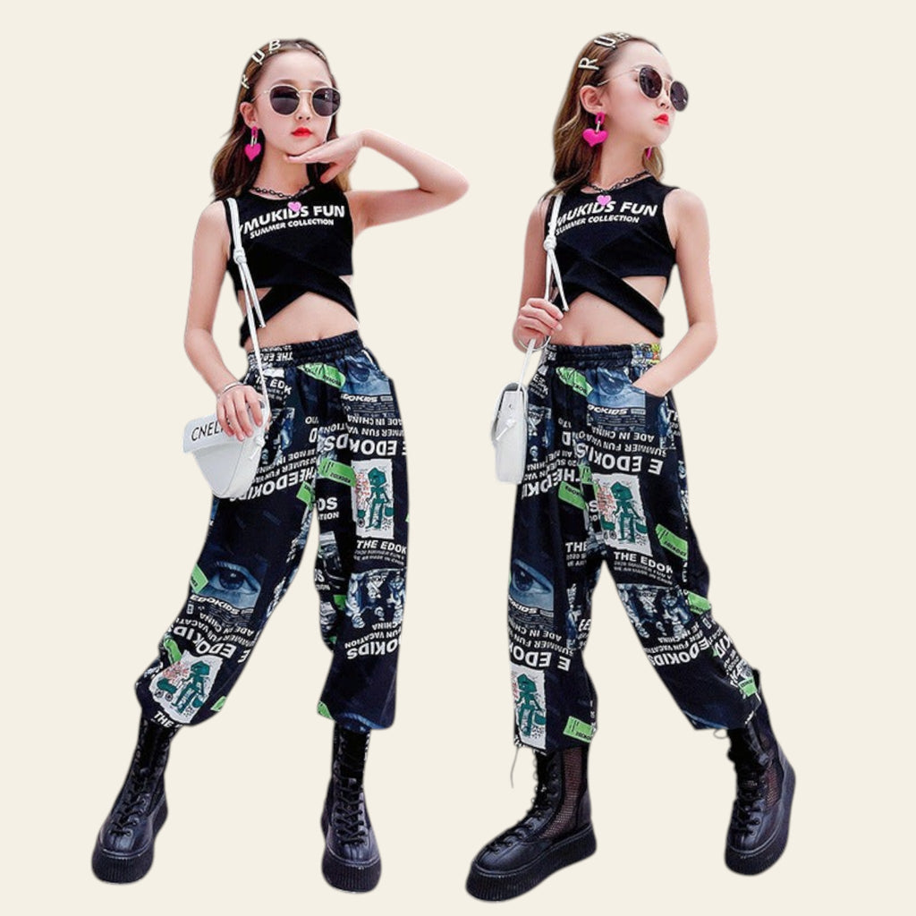 Two women in matching outfits with graphic pants and black tops in a modern indoor setting.