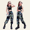 Two women in matching outfits with graphic pants and black tops in a modern indoor setting.