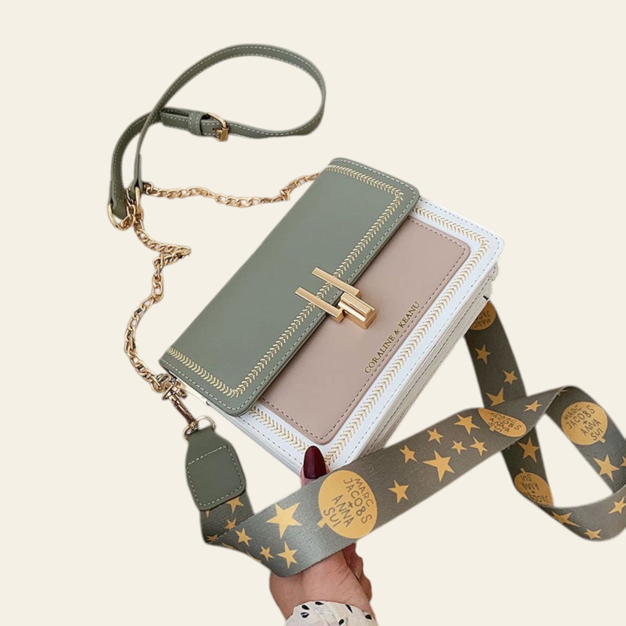 Green handbag with star-patterned strap on a beige surface