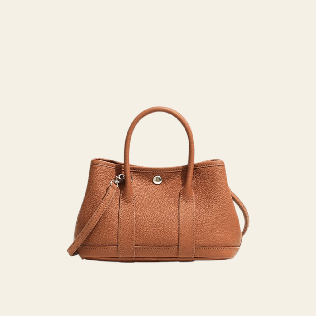 Brown handbag with a strap on a white background