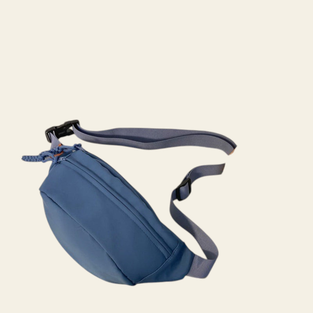 Blue waist bag on a surface with a book and snack packet in the background