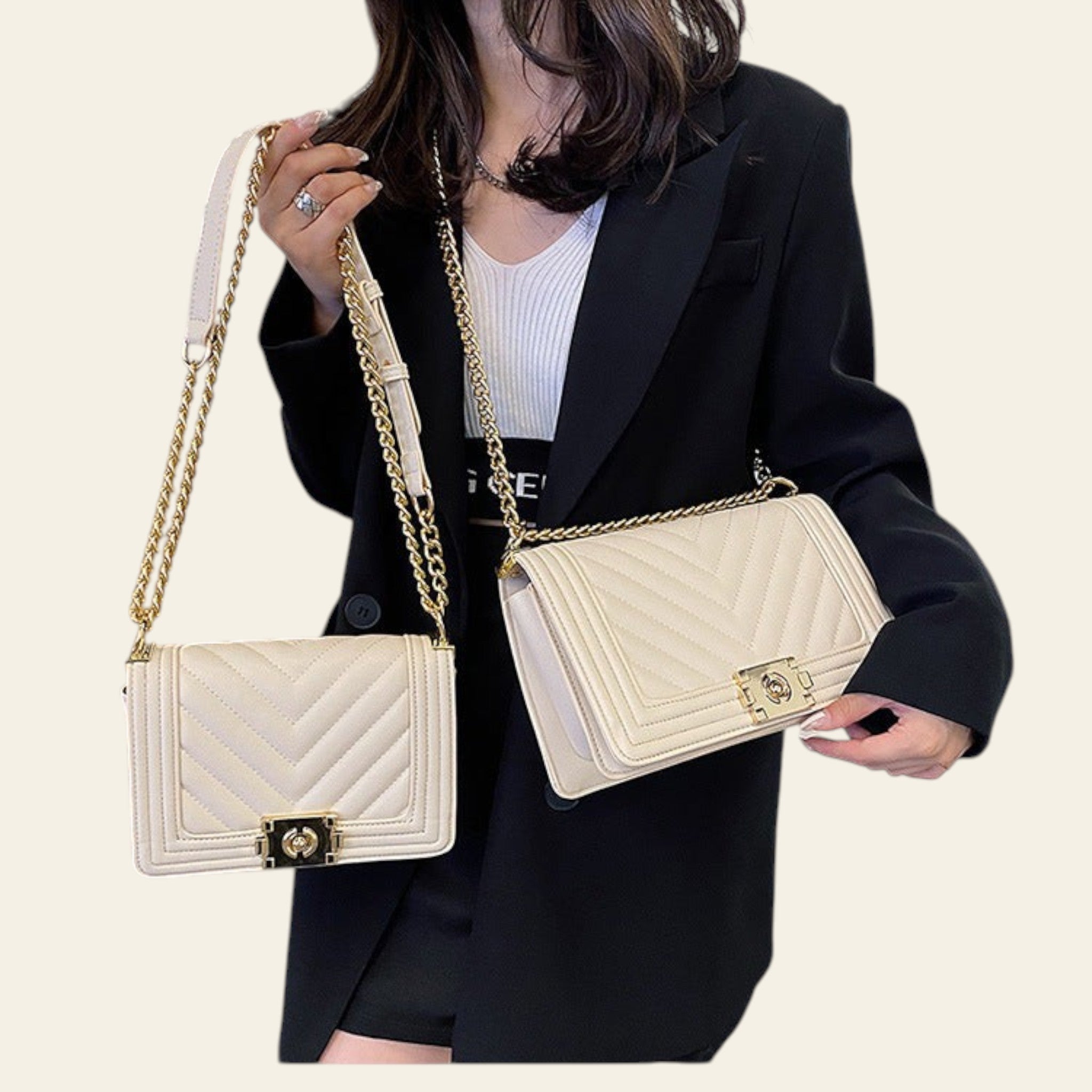 Person holding two white handbags with gold chains in an indoor setting
