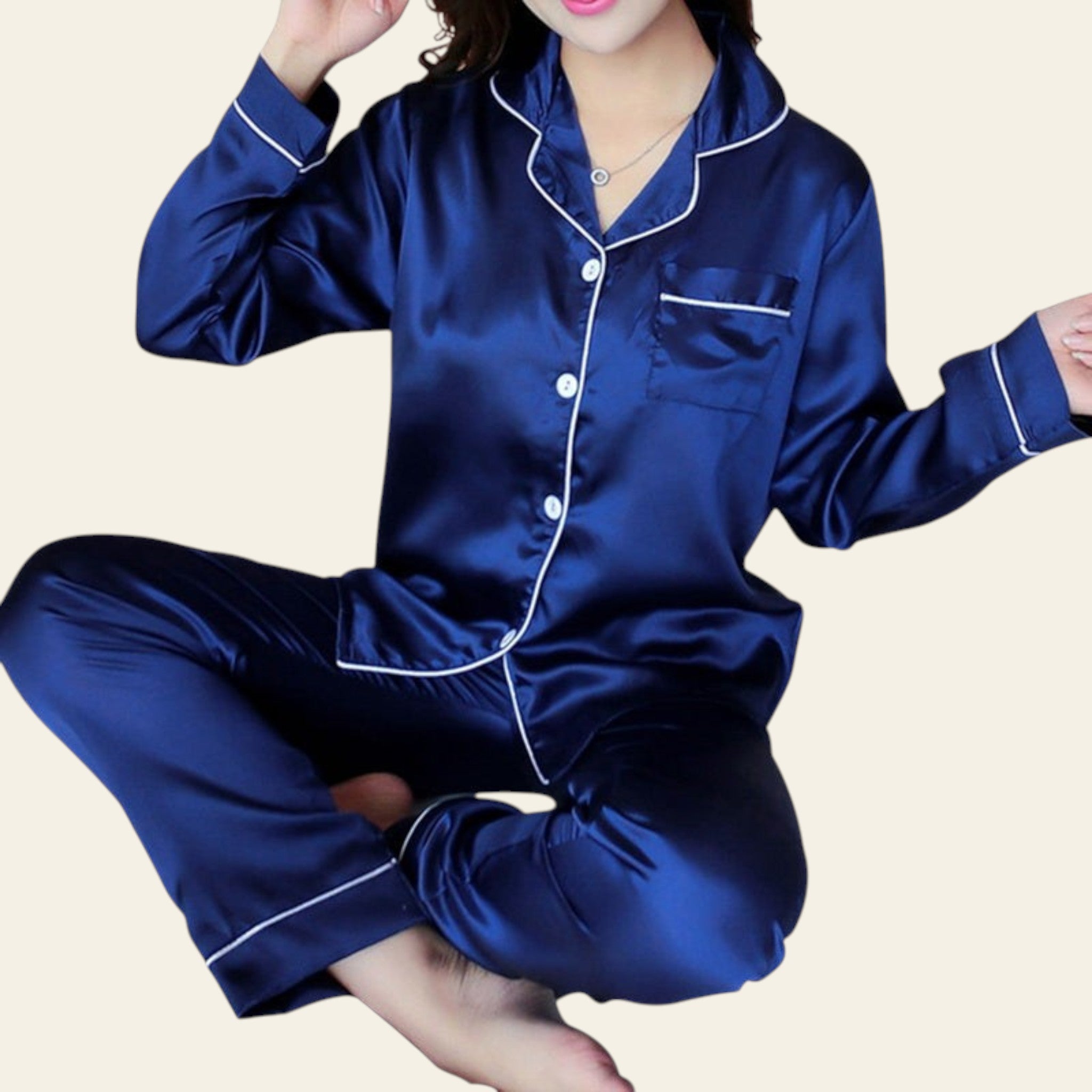 Blue satin pajama set with white trim worn by a person on a dark background