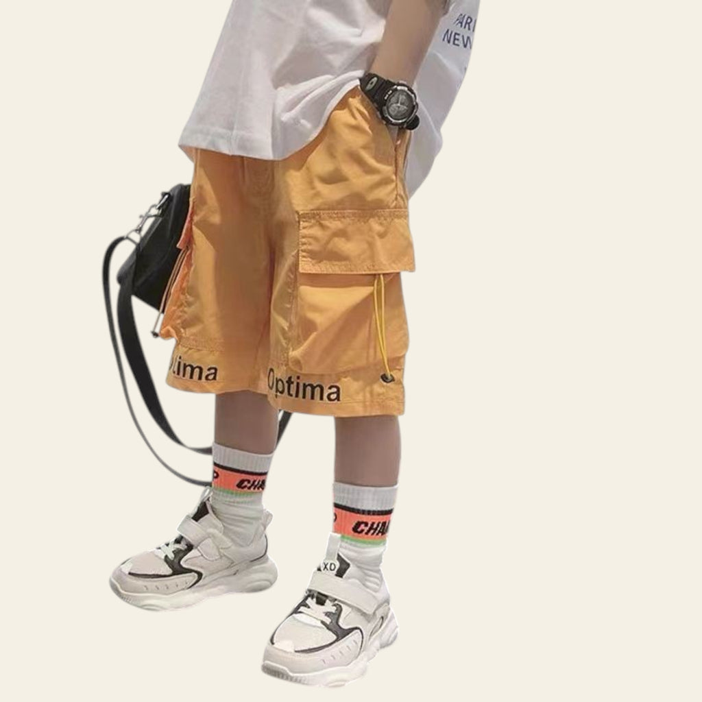 Person wearing yellow cargo shorts with visible branding, standing on a white surface.
