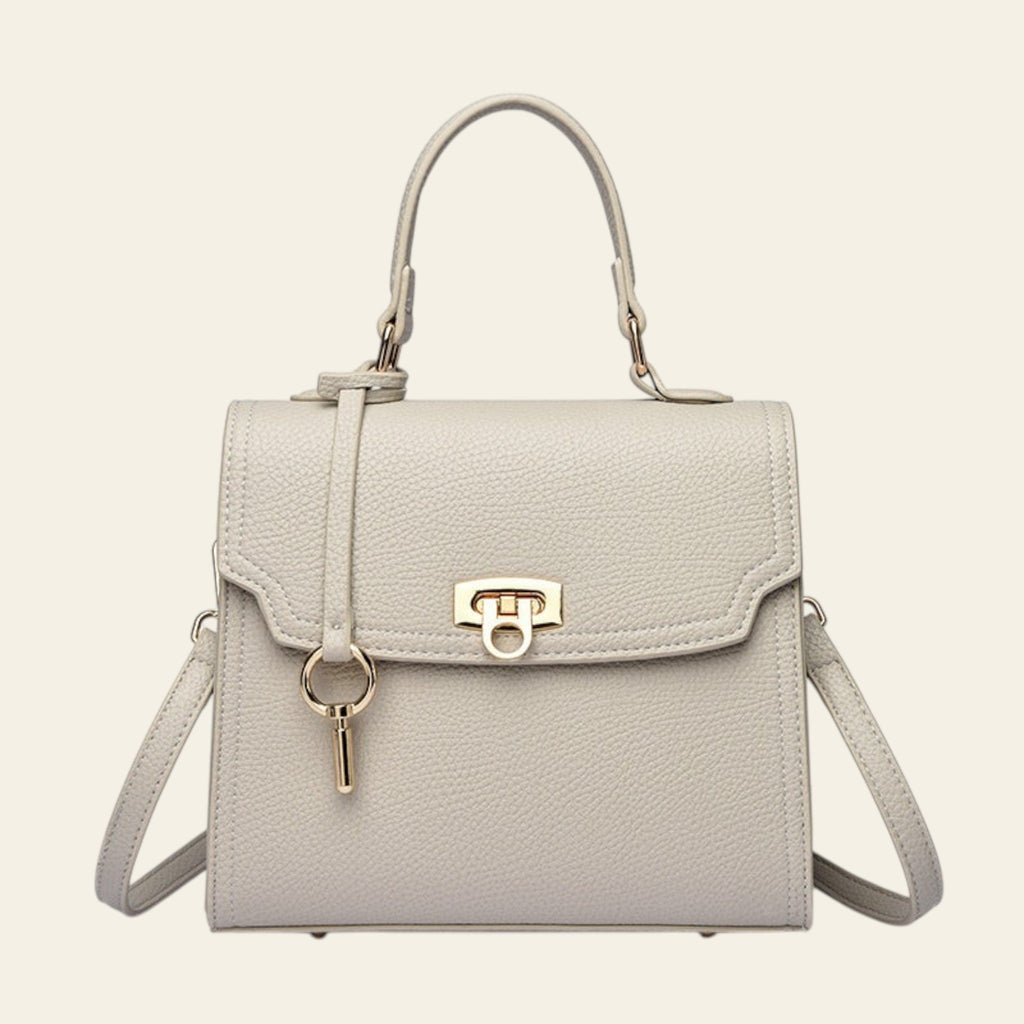 Light gray handbag with a gold clasp on a white background