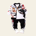Children's outfit with colorful jacket, white shirt, black pants, and white sneakers on a gray background.