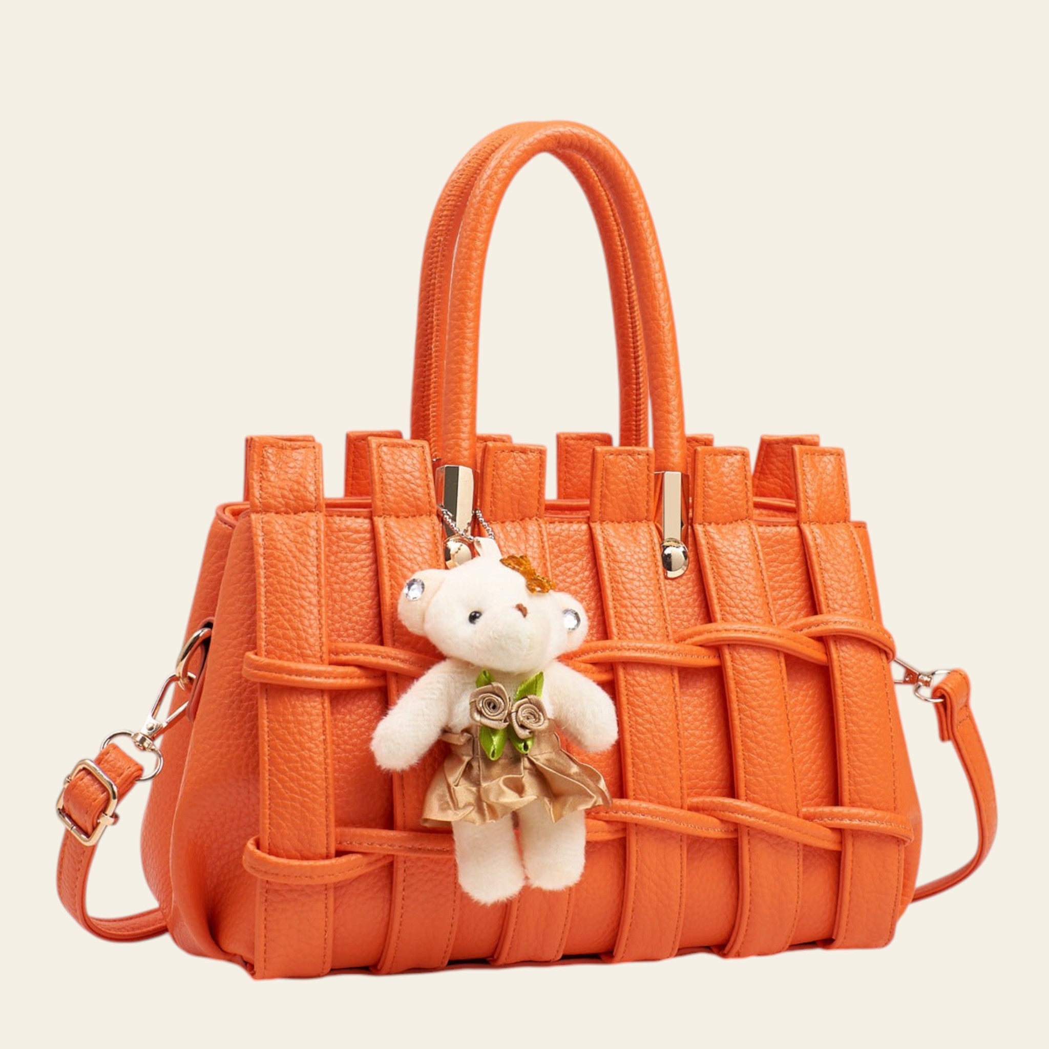 Orange woven handbag with a teddy bear keychain on a light gray background
