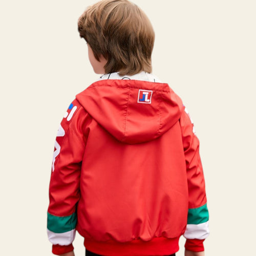 Person wearing a red jacket with a brand logo, standing in an urban setting.