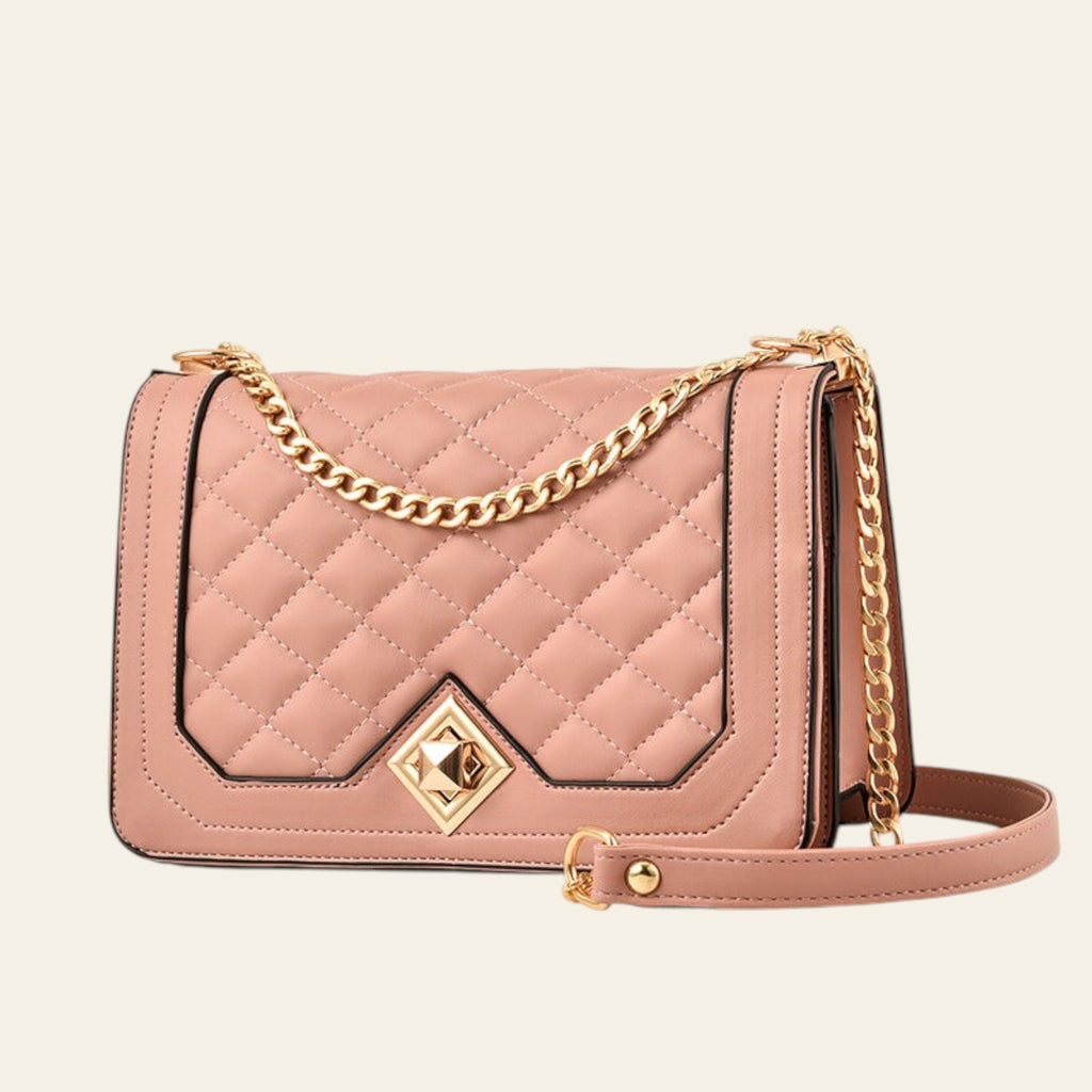 Pink quilted handbag with gold chain strap on a white background