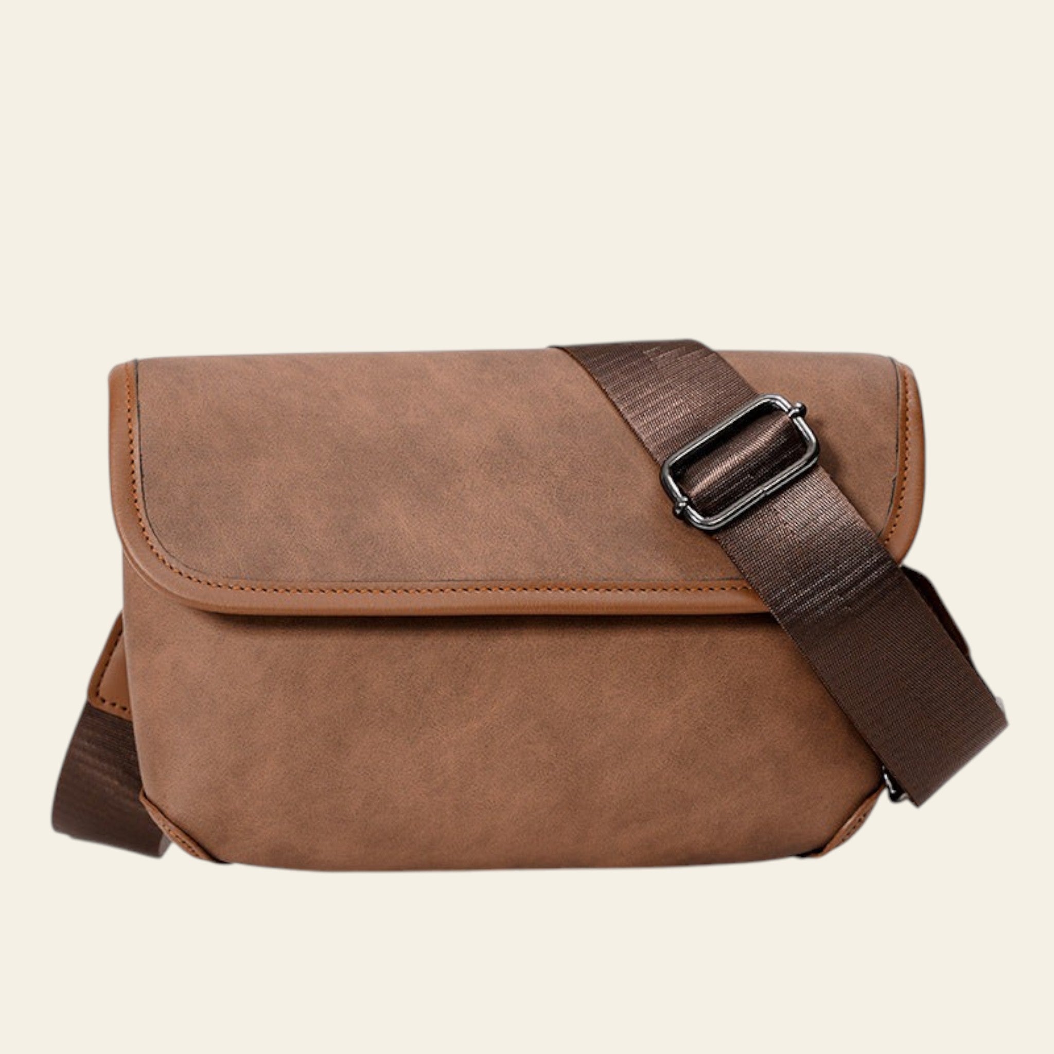 Brown leather messenger bag with a strap on a white background