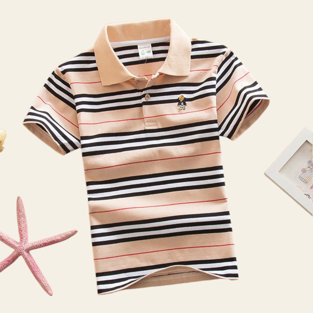 Striped polo shirt on a beige surface with decorative items