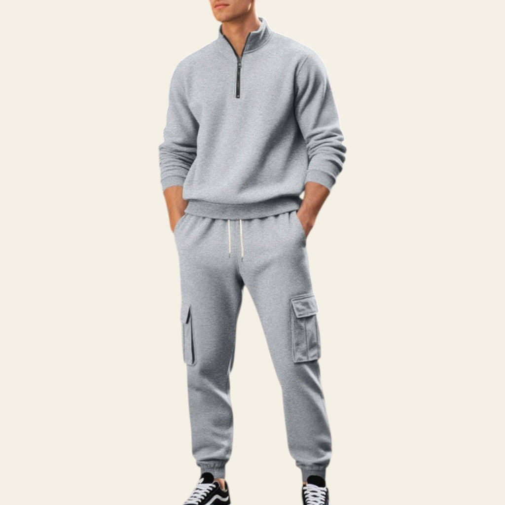 Man wearing a light gray fleece-lined tracksuit set with zip-up jacket and jogger pants on a city street