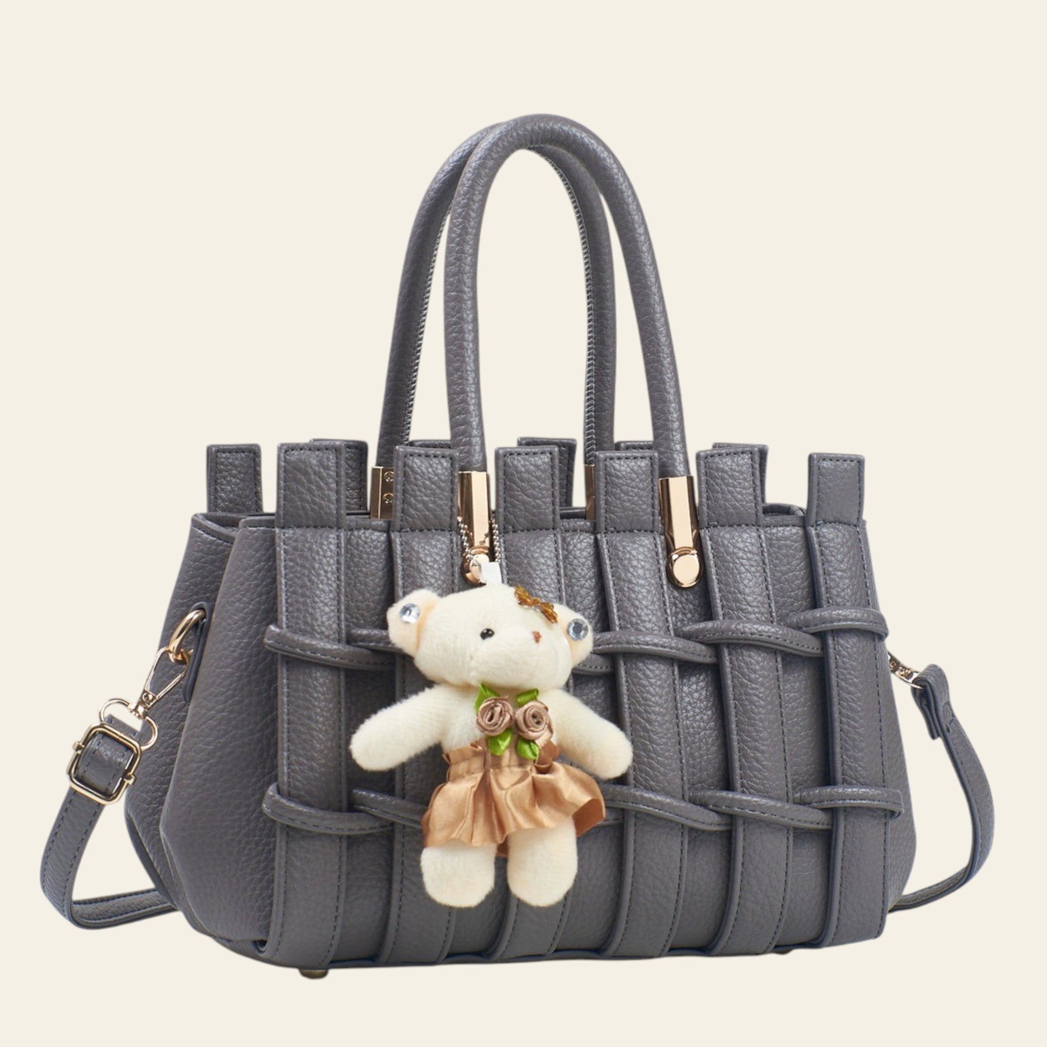 Gray woven handbag with a teddy bear keychain on a light background