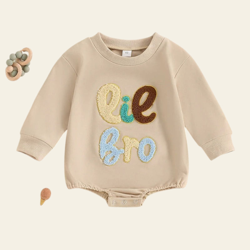 Beige baby romper with colorful text on a light beige background