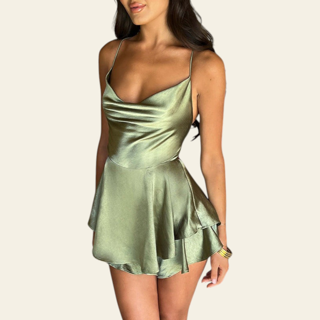 Woman wearing a green satin dress standing indoors.