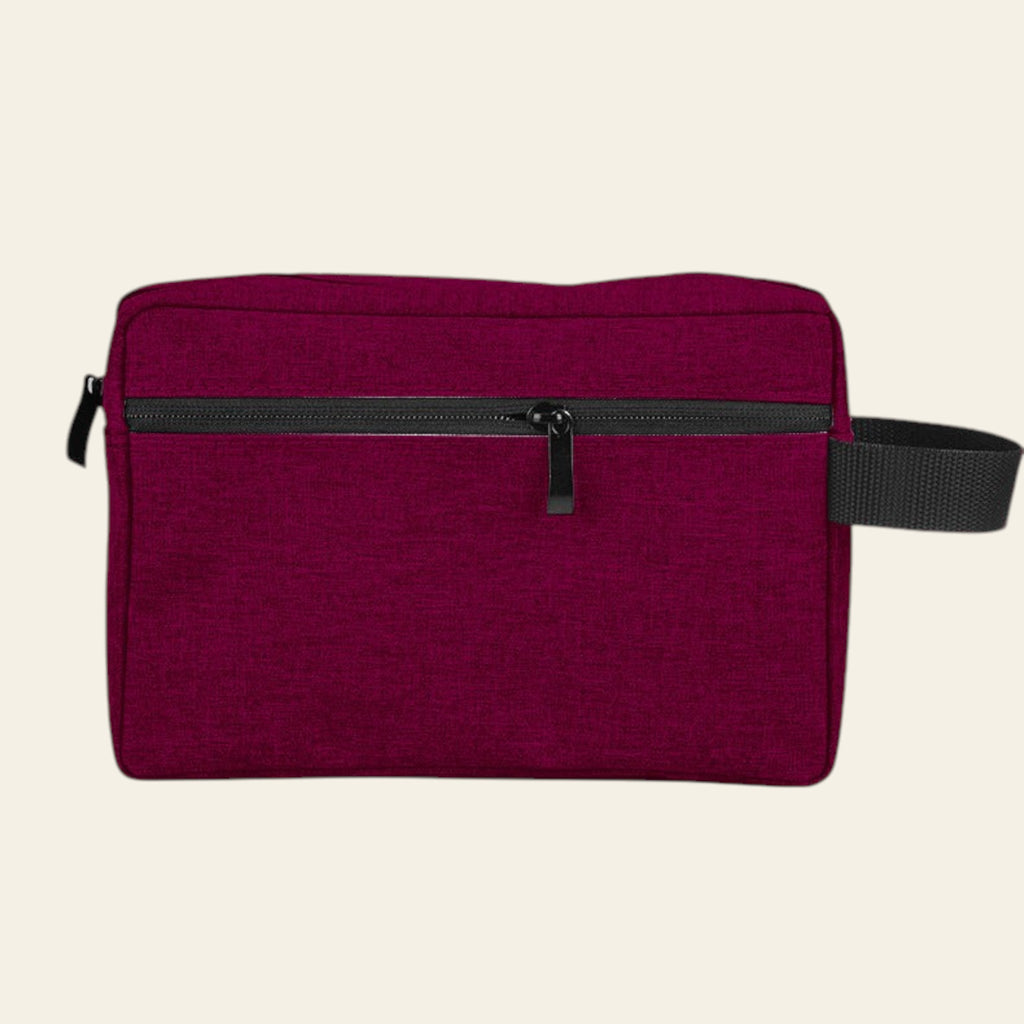 Maroon toiletry bag with black zipper and strap on a white background