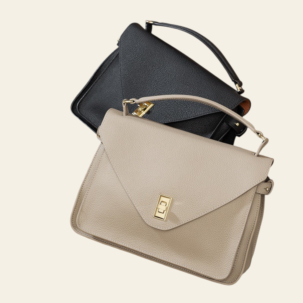 Two handbags, one black and one beige with a gold clasp, on a textured surface.